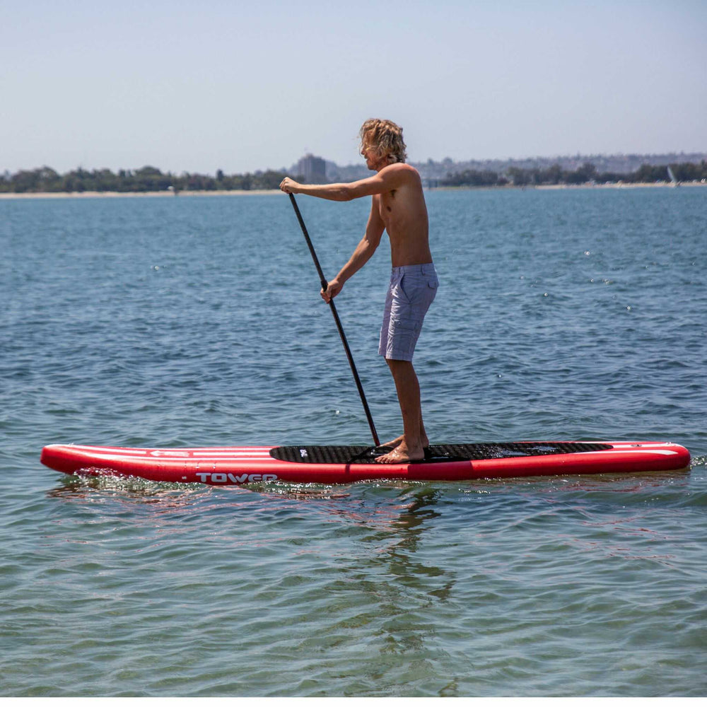 man riding red Tower paddle board