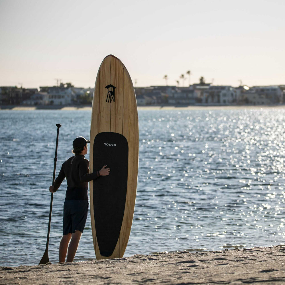 Man standing with a Tower wood paddle board