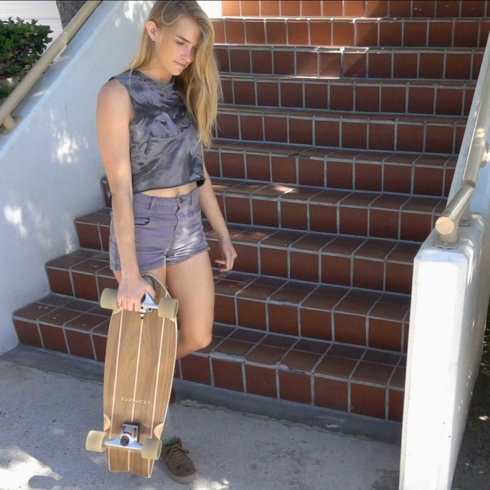 Woman standing with mini cruiser skateboard from Tower