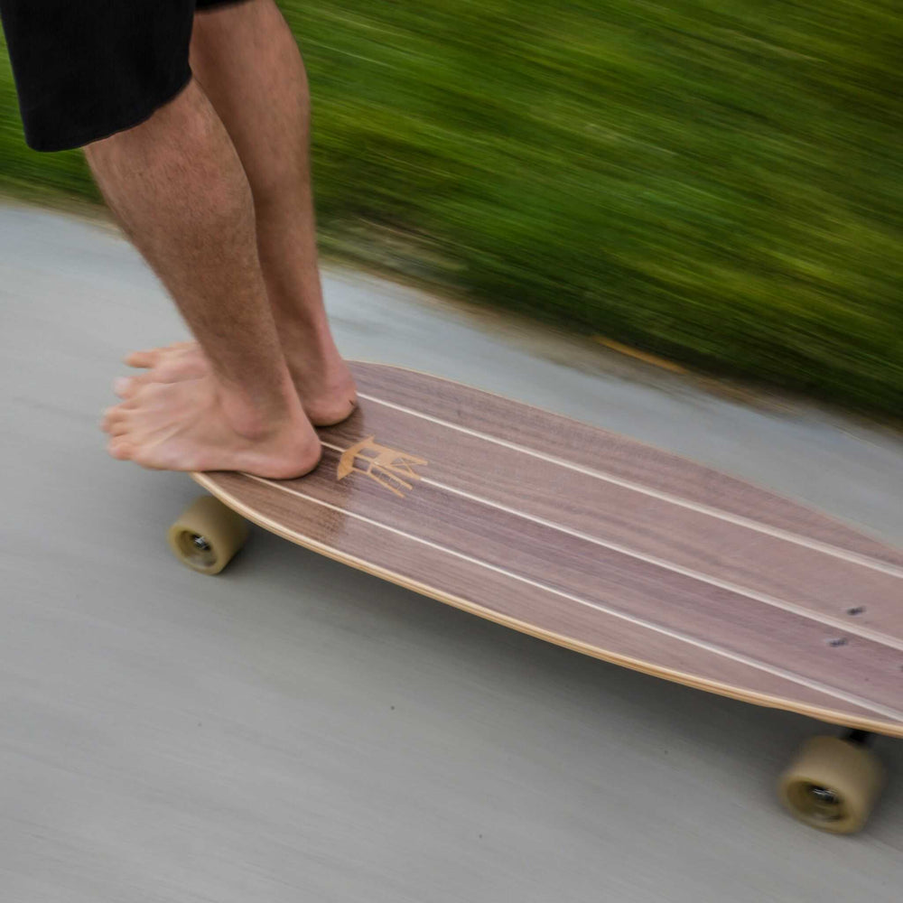 A person hanging ten on a Tower boardwalk cruiser skateboard