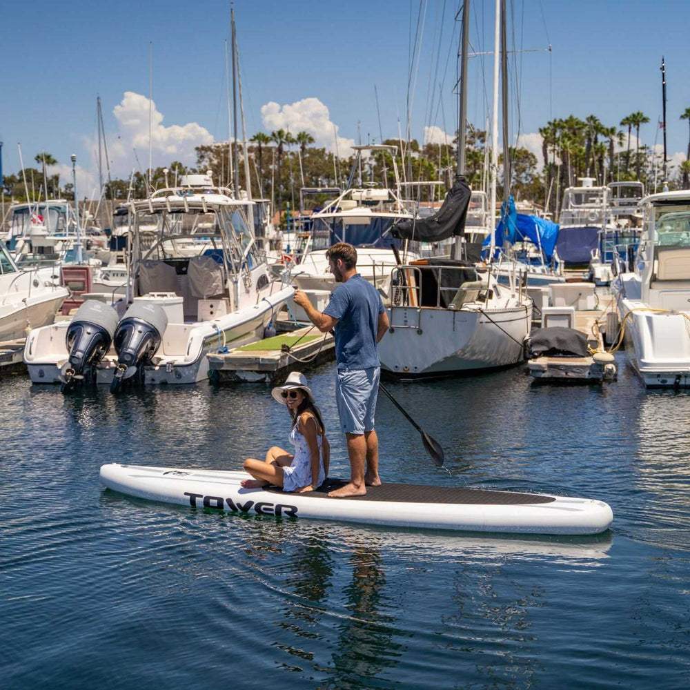 Couple paddling through a Marina on a Tower paddle board