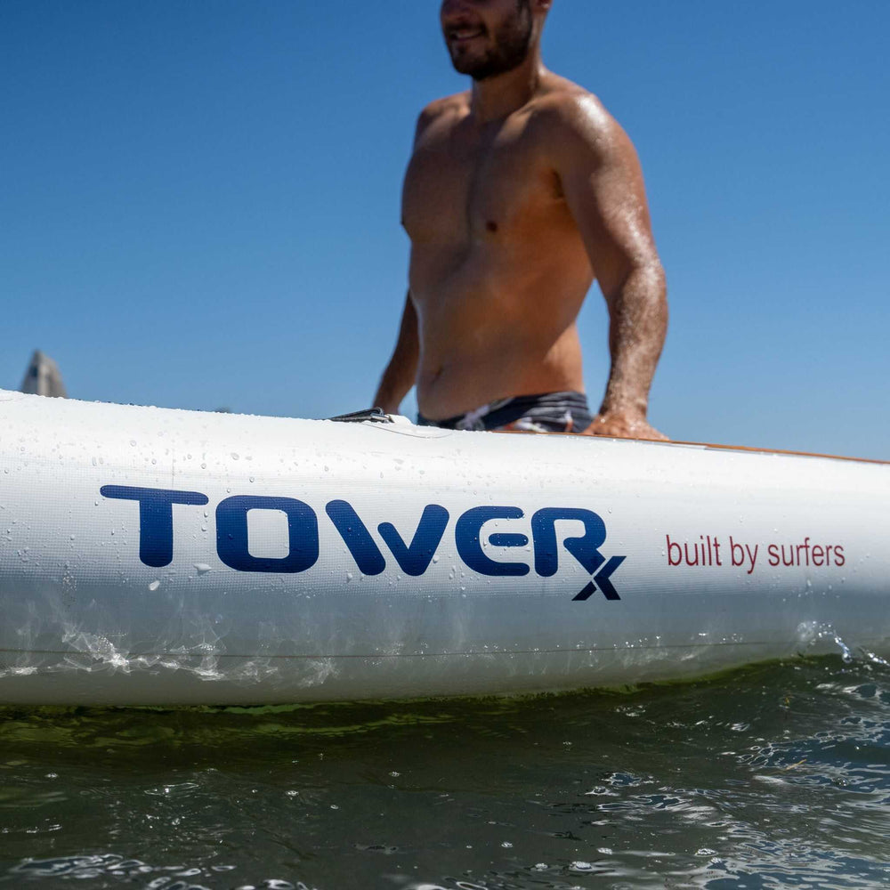 Man standing next to the Tower X-Class logo