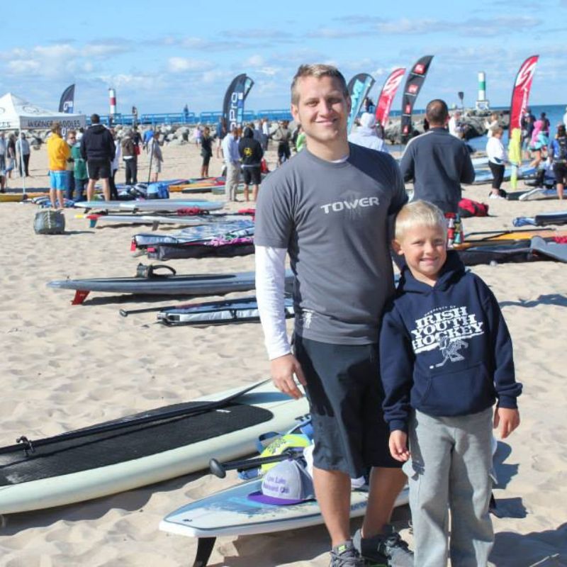 Man wearing Tower paddle boards shirt on the beach