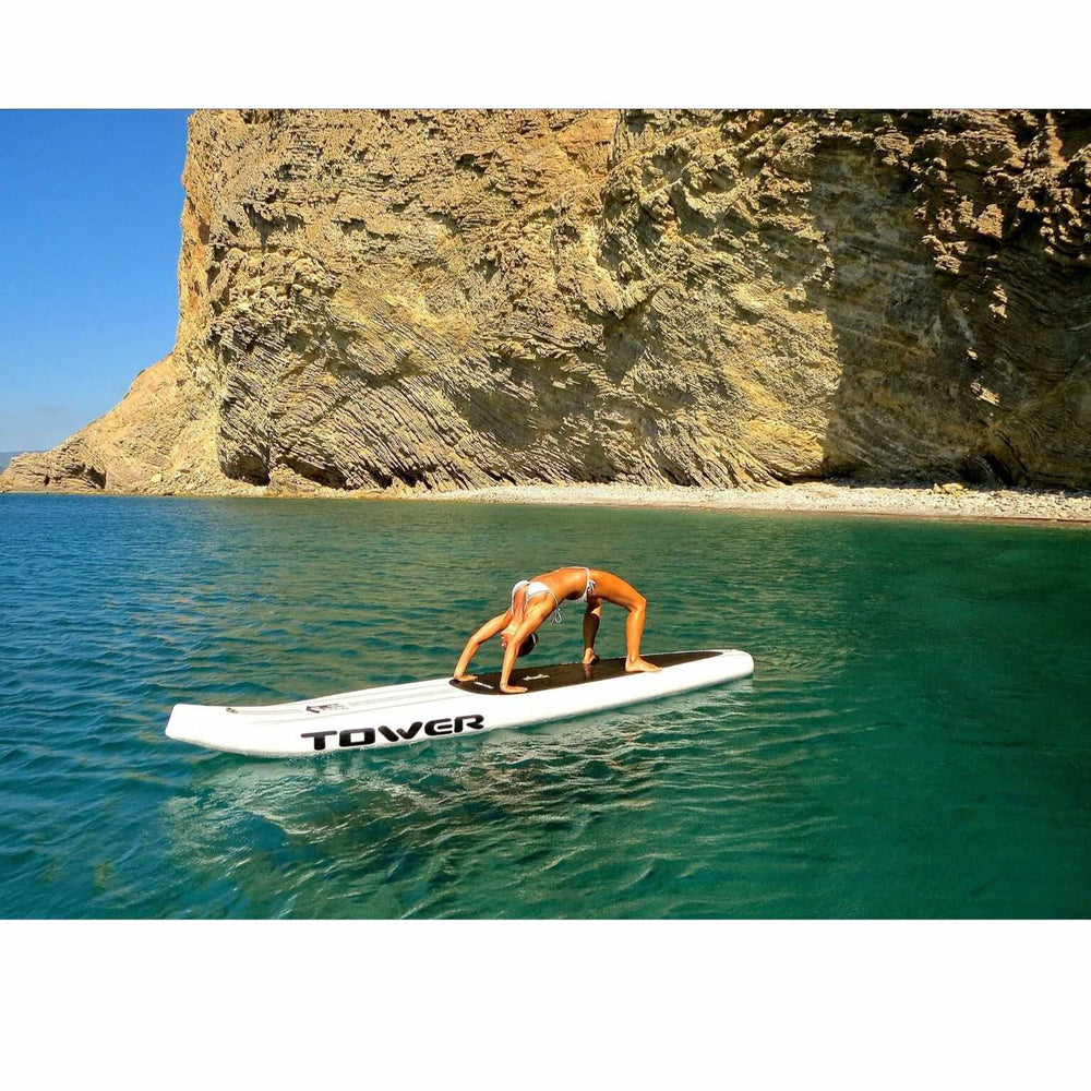 Woman doing yoga on a Tower paddle board in the ocean