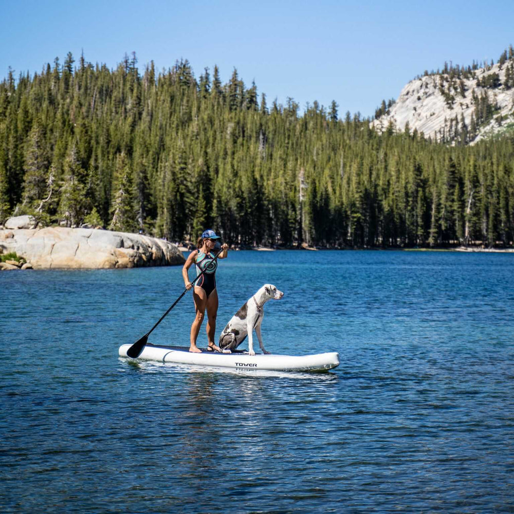 woman and dog on Tower paddle board in mountain lake