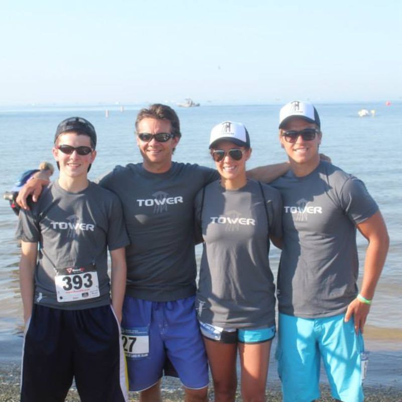 Group of people wearing Tower paddle boards shorts in front of the water