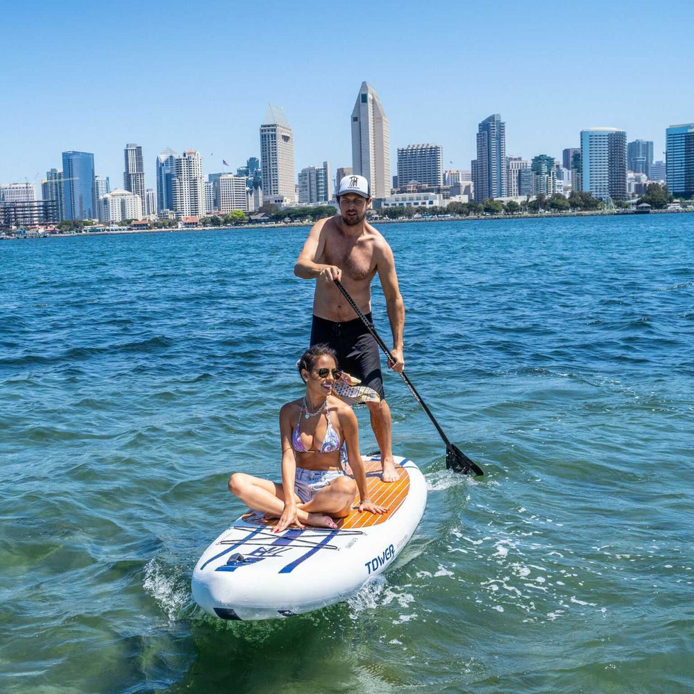 Man and woman paddling on X-Class paddle board while in front of San Diego skyline