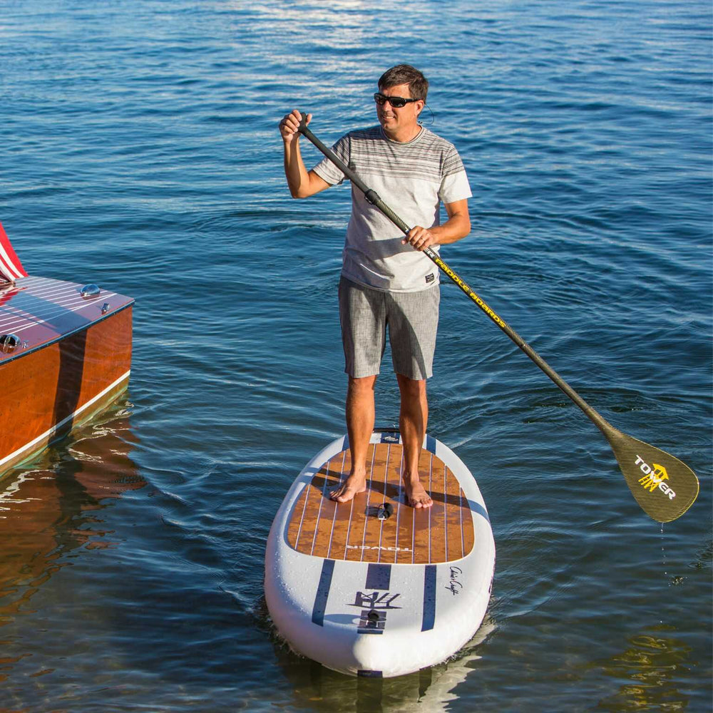 Man riding a Tower paddle board with a carbon Kevlar paddle