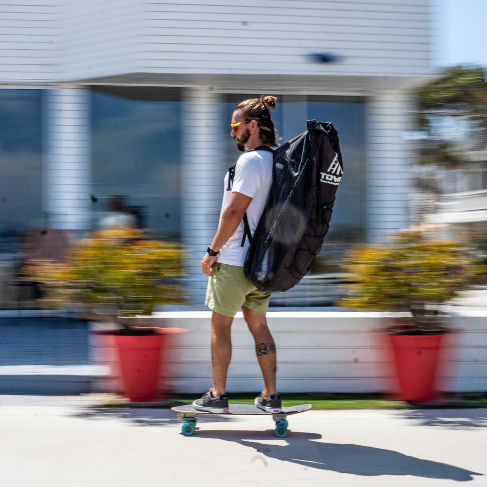 Man riding a skateboard while wearing a full iSUP backpack from Tower