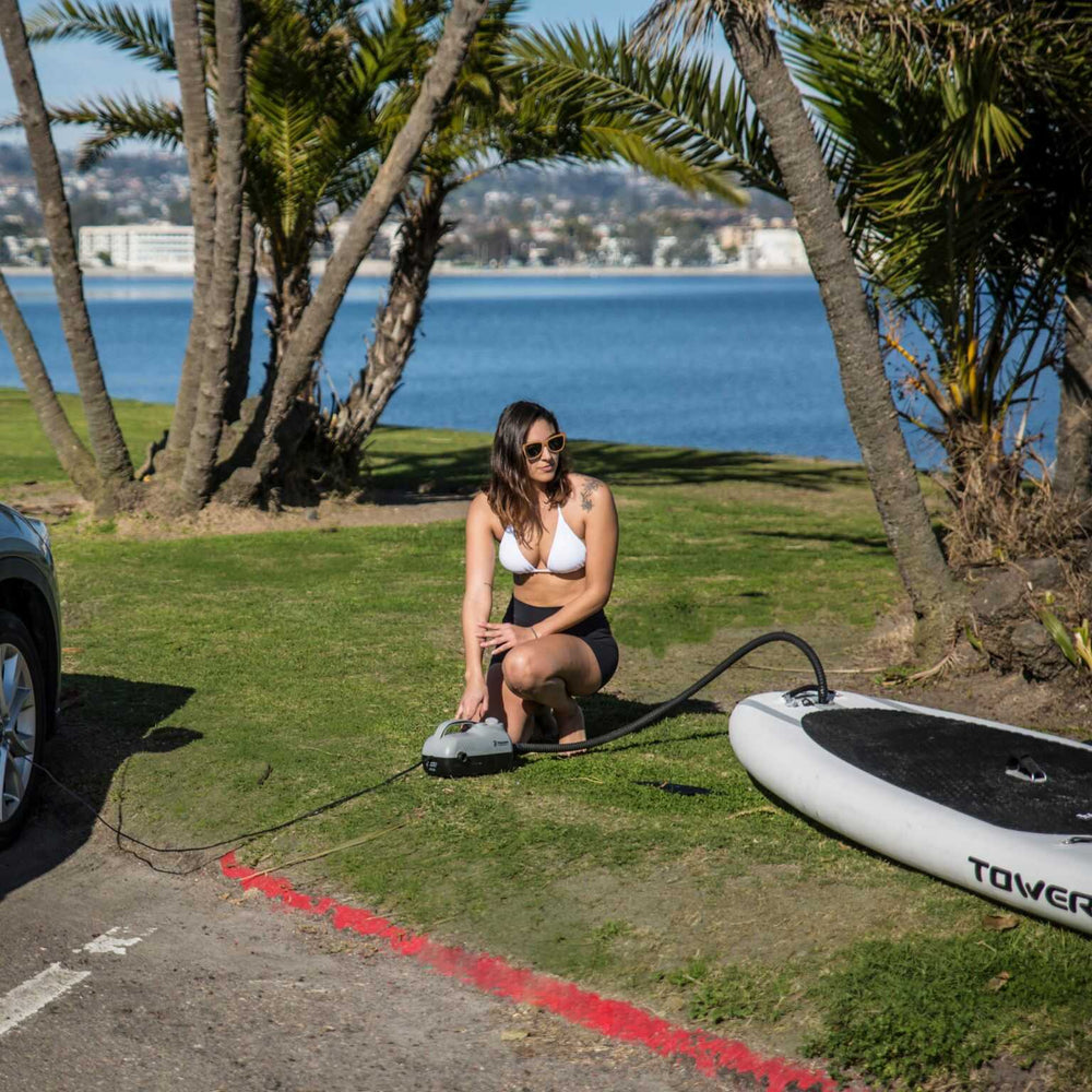 Woman using the electric paddle board pump from Tower 