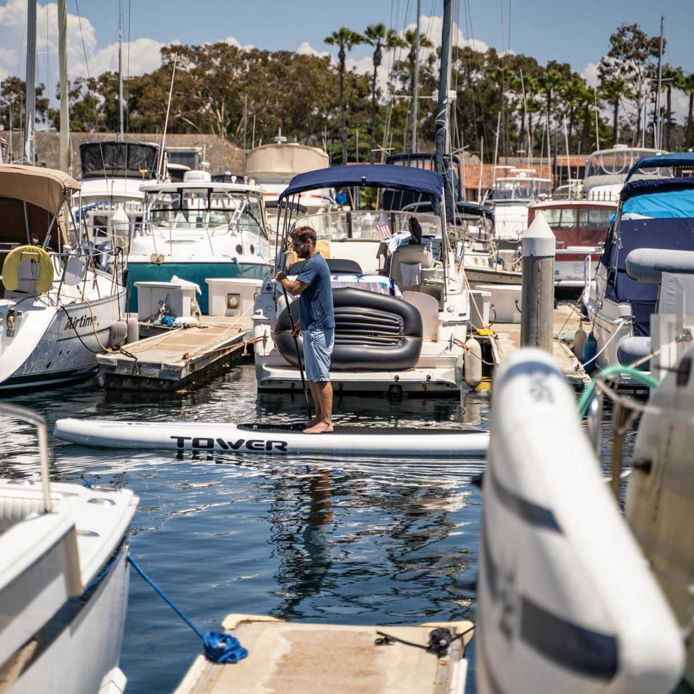 Man riding a Tower Xplorer board through a marina