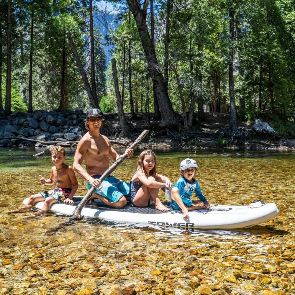 Family on a Tower paddle board in a shallow pond