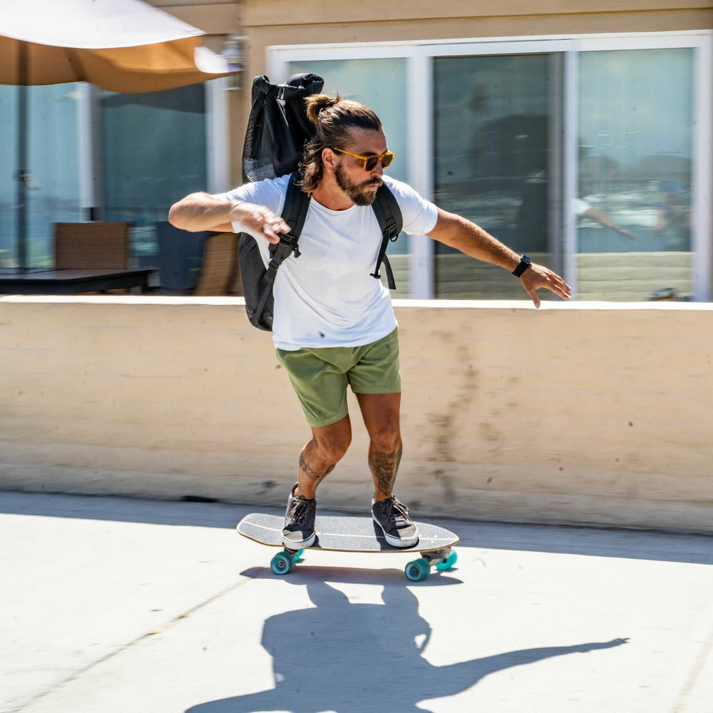 Man turning on a skateboard while wearing an iSUP backpack from Tower