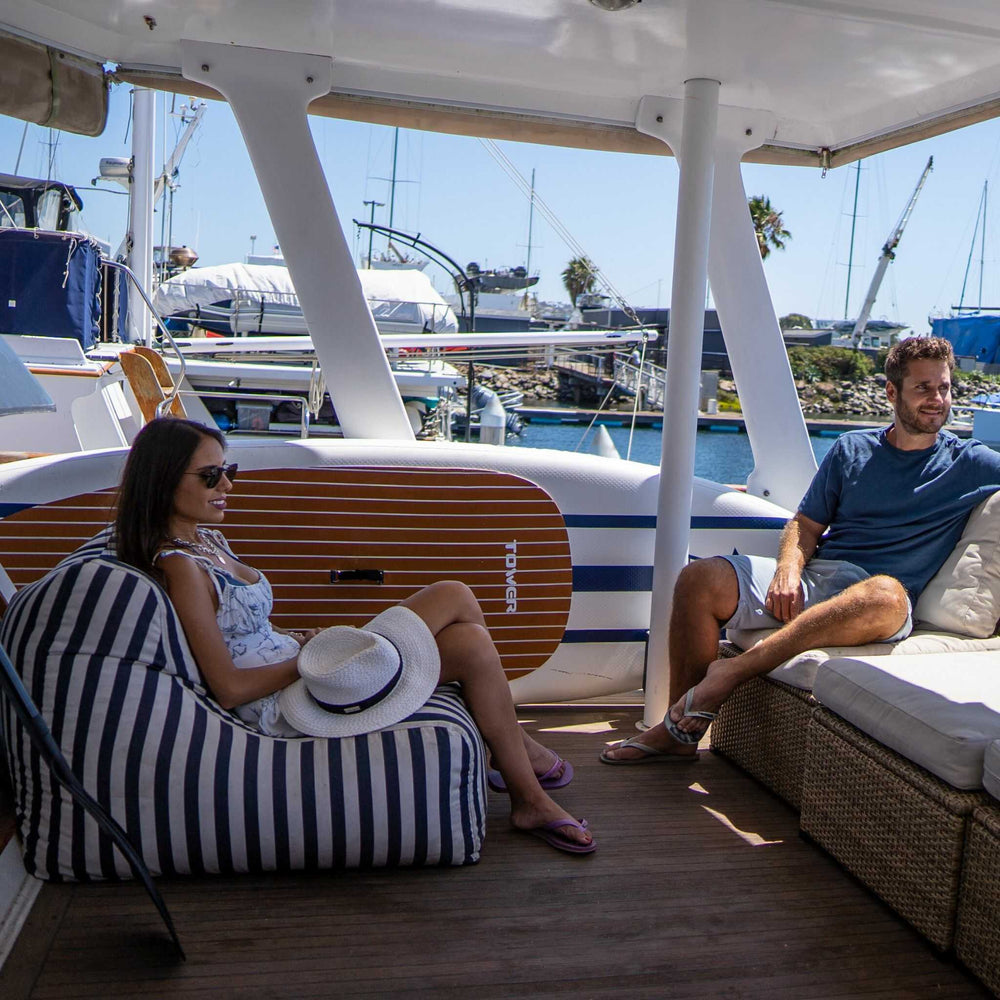 Couple sitting on a boat with a Tower paddle board stashed on it