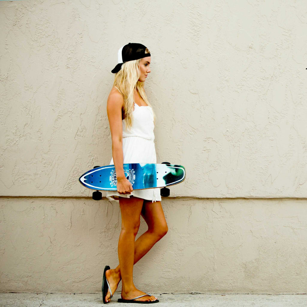 Girl with skateboard wearing a Tower trucker hat