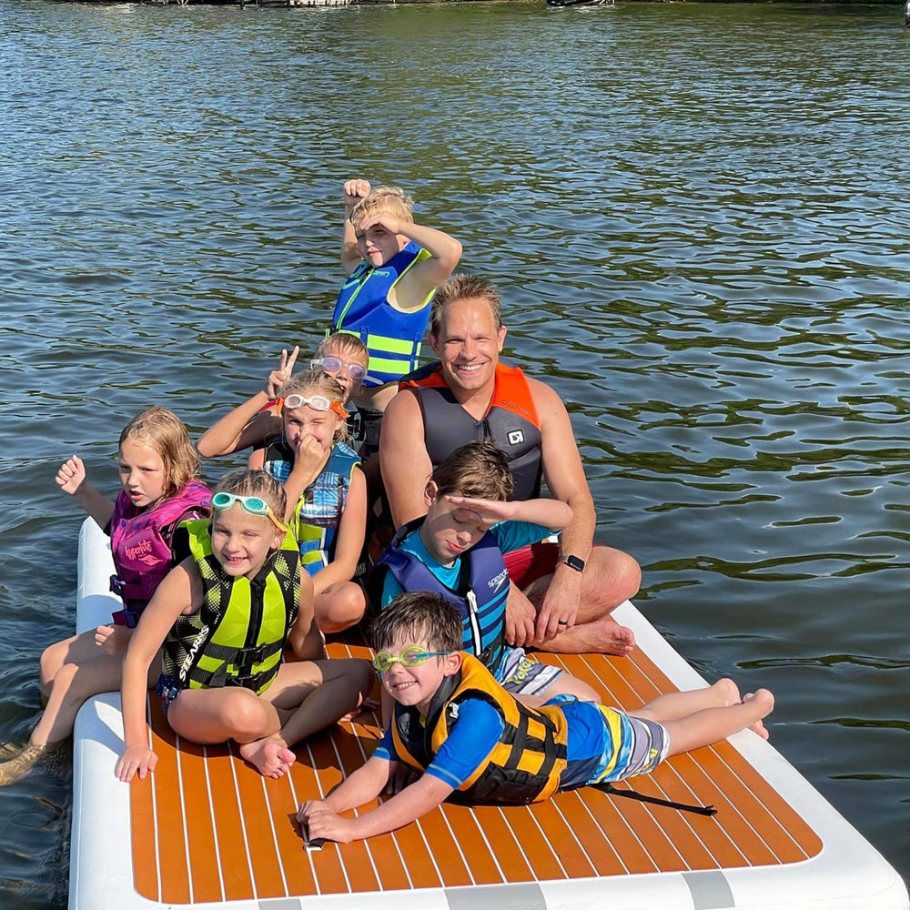 Group of children hanging out on a Tower swim step in the water