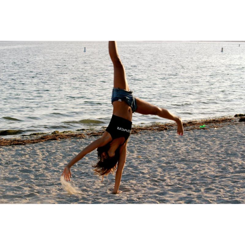 Woman doing a cartwheel in a Tower tank top