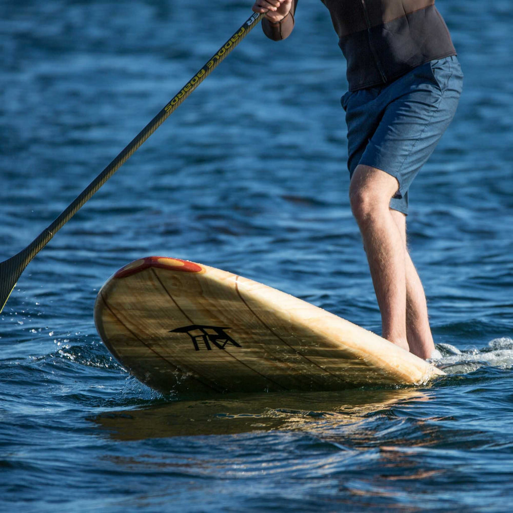 Tower wood paddle board lifting out of the water