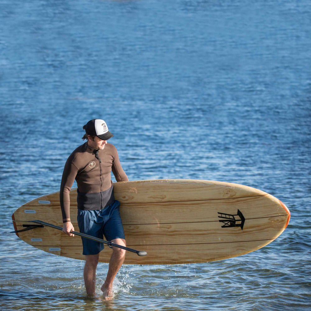 Man carrying a Tower wood paddle board